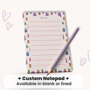 May include: A lined notepad with a colorful macaron border and the word "NOTES" at the top. A lavender pencil rests on the notepad. The text "Custom Notepad" and "Available in blank or lined" is at the bottom.