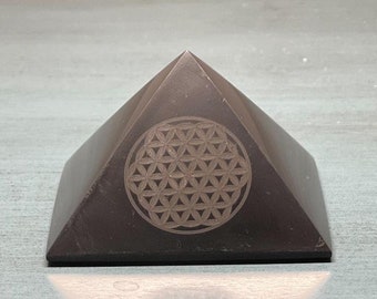 May include: A black obsidian pyramid with a flower of life design etched into the front face.