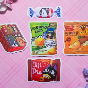 以下が含まれることがあります： ピンクの背景に白いグリッドパターンが施された、漫画のキャラクターと食べ物を描いたカラフルなステッカー5枚。ステッカーには、トトロのキャラクターが描かれた弁当箱、豚のキャラクターが描かれたチップスの袋、猫のキャラクターが描かれたチップスの袋、ウサギのキャラクターが描かれたキャンディーの包み紙、黒い猫のキャラクターが描かれたパイの箱が含まれています。
