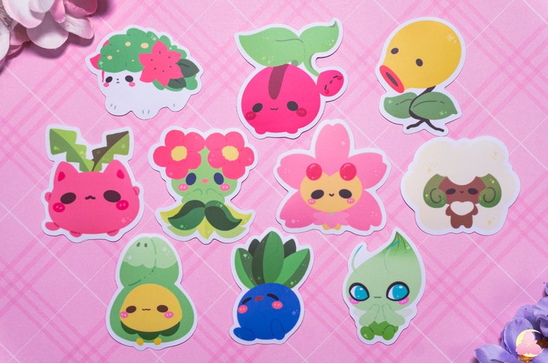 May include: A set of ten colorful cartoon stickers featuring various plant and flower characters. The stickers are on a pink background with a grid pattern.