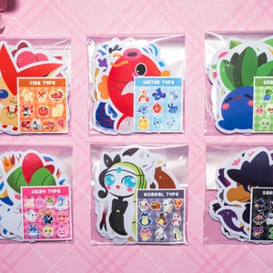 May include: Six clear plastic bags each containing a set of colorful cartoon stickers. Each bag has a different Pokemon type: Fire, Water, Grass, Fairy, Normal, and Dark. Each set includes a larger sticker of a Pokemon and a smaller sheet of stickers with various Pokemon of that type.