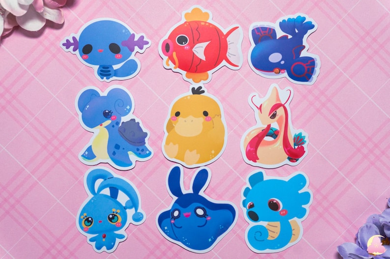 May include: Nine colorful cartoon stickers featuring various sea creatures. The stickers are on a pink and white checkered background. The stickers include a blue fish, a yellow duck, a pink and white seahorse, a blue turtle, a blue and white jellyfish, a blue and white seahorse, a blue and white crab, a red and white fish, and a blue and white octopus.