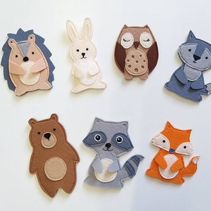 May include: Set of felt animal finger puppets, including a brown bear, a gray raccoon, a gray wolf, a brown owl, a white rabbit, and an orange fox.