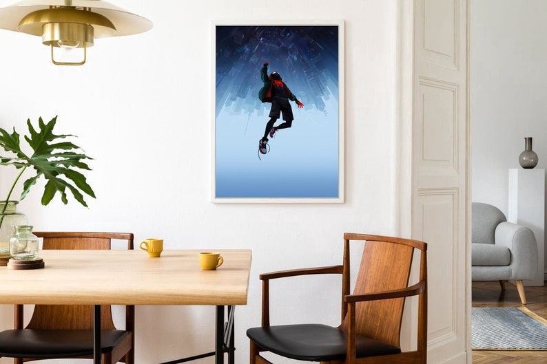 May include: A framed poster featuring a silhouette of a person in a red and black suit, with a green jacket, jumping in front of a city skyline. The background is a blue gradient with white stars.