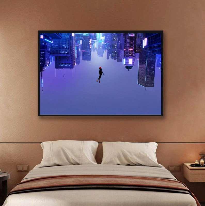 May include: A framed art print depicts a person in a red suit floating in front of an upside-down cityscape. The buildings are illuminated with neon lights in shades of blue and purple. The artwork is displayed above a bed with white pillows and a brown blanket.