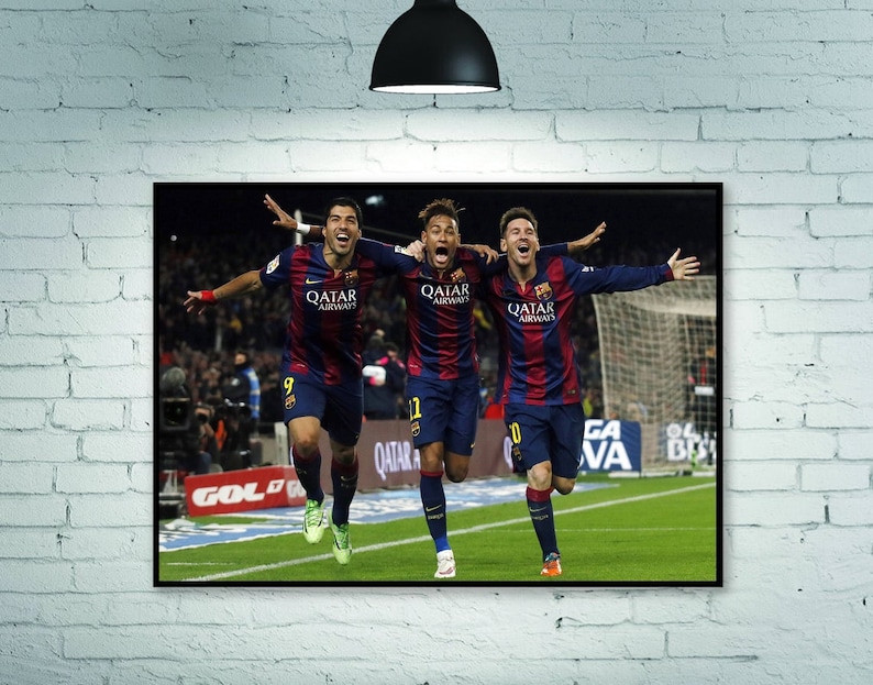 May include: Three soccer players in red and blue uniforms celebrate a goal. The players are wearing jerseys with the text "Qatar Airways" on the front. The players are on a green field with a soccer goal in the background.