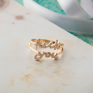 Puede incluir: Un anillo de oro con las palabras "fuck you" escritas en pequeños diamantes.