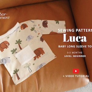 May include: A baby long sleeve top sewing pattern named "Luca" with an elephant and palm tree print. The pattern is for babies 0-3 months old and is beginner level. The image includes the text "+ VIDEO TUTORIAL".
