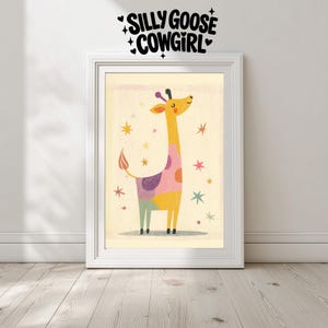 Peut inclure: Une affiche encadrée avec une illustration de girafe fantaisiste. La girafe a un long cou jaune, des taches colorées et est entourée d'étoiles. Le texte "SILLY GOOSE COWGIRL" est au-dessus du cadre.