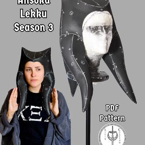 May include: A black headpiece with white printed construction lines and markings, labeled Ahsoka Lekku Season 3 PDF Pattern. The headpiece features two long, curved side extensions and a central crown, displayed on a mannequin head and worn by a person.