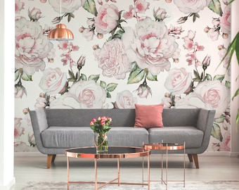 Puede incluir: Un sofá gris con un cojín rosa delante de una pared con un papel tapiz floral con rosas rosas y hojas verdes.