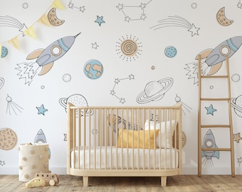 May include: A white wall with a space-themed mural featuring planets, stars, rockets, and constellations. A wooden crib with a white mattress and a yellow pillow is in front of the wall. A wooden ladder is leaning against the wall.