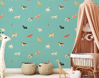 May include: A teal blue wallpaper with a repeating pattern of various dog breeds in different colors and poses. A white giraffe stuffed animal stands in the foreground, and a wicker bassinet with a peach-colored canopy is in the right corner.