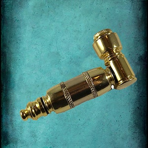May include: A gold metal pipe with a curved stem and a round bowl. The pipe is made of brass and has a shiny finish.