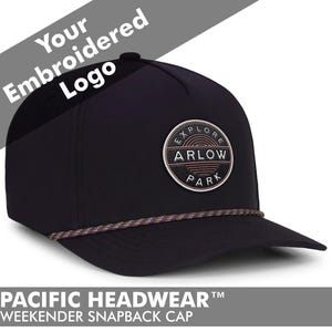 May include: Black snapback cap with a circular patch that reads "EXPLORE ARLOW PARK". The cap has a curved brim and a decorative rope detail. The text "Your Embroidered Logo" is above the cap. The text "PACIFIC HEADWEAR WEEKENDER SNAPBACK CAP" is below the cap.