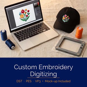 May include: A laptop shows a floral embroidery design, alongside a black cap with a similar embroidered flower. Blue and orange thread spools and an embroidery hoop are also visible. The image includes the text "Custom Embroidery Digitizing".