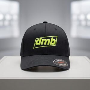 Peut inclure: Casquette de baseball noire avec les lettres "dmb" brodées en vert néon. La casquette a une visière incurvée et un autocollant Flexfit. Le texte "Free Auto-Digitized Mockup" est visible en arrière-plan.