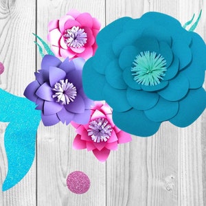 May include: A turquoise mermaid tail with glitter accents and four paper flowers in shades of pink, purple, and blue. The flowers are layered and have a 3D effect.