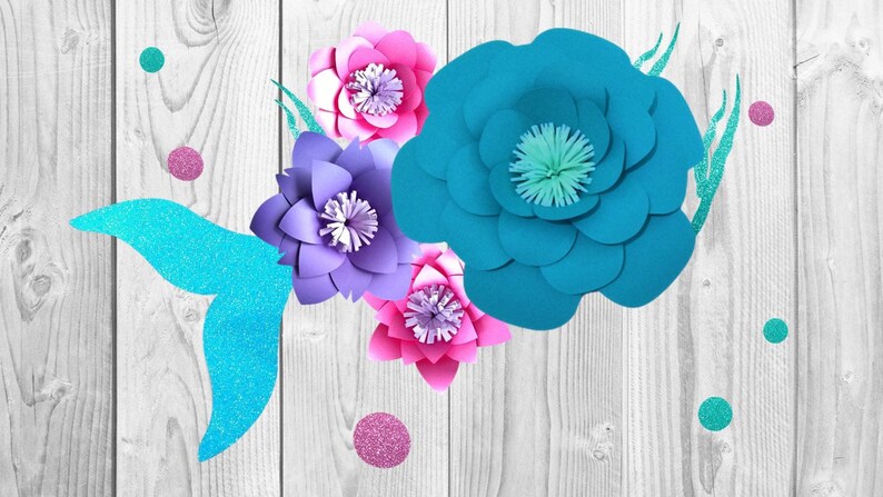 May include: A turquoise mermaid tail with glitter accents and four paper flowers in shades of pink, purple, and blue. The flowers are layered and have a 3D effect.