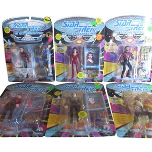 May include: Six Star Trek: The Next Generation action figures in their original packaging. Each figure is in a clear plastic bubble attached to a colorful cardboard backing. The packaging features the Star Trek logo and character images.