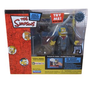 May include: A boxed "The Simpsons" Dr. Dolittle action figure. The figure is wearing a gray suit and has a yellow face with a white mustache. The packaging includes text such as "World of Springfield" and "Be Sharp Centennial."