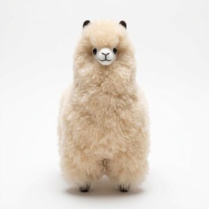 Op de afbeelding: Een staand alpaca-knuffel met een cr&egrave;mekleurig, pluizig lichaam. De alpaca heeft zwarte ogen, een wit gezicht en kleine zwarte oren. Het speelgoed is ontworpen om op een echte alpaca te lijken.
