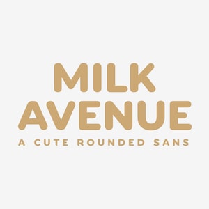 Puede incluir: Logotipo de la fuente Milk Avenue en un estilo sans-serif redondeado. El logotipo es de color marrón claro sobre un fondo blanco.