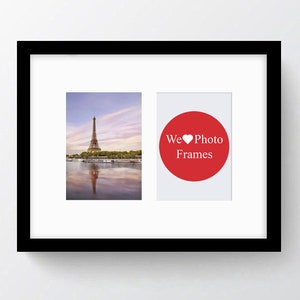 May include: Black picture frame with a white mat and two openings for photos. The left opening shows a photo of the Eiffel Tower in Paris, France. The right opening shows a red circle with the text "We ♥ Photo Frames".
