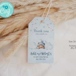 Puede incluir: Etiqueta de agradecimiento para una fiesta de bienvenida al bebé de color azul y blanco con una ilustración de un oso de peluche durmiendo. La etiqueta dice "Gracias por venir a la fiesta de bienvenida al bebé de Ashley & Robert el 13 de julio de 2024". La etiqueta mide 2 x 3,5 pulgadas y está disponible en los formatos JPG, PDF y PNG.