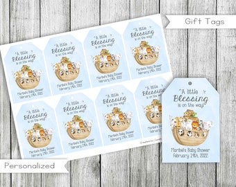 May include: A set of 8 blue and white gift tags with a cartoon illustration of a Noah's Ark with animals. The text on the tags reads "A little blessing is on the way!" and includes the name of the baby shower and the date.