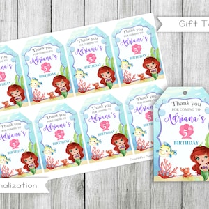 May include: Set of 8 printable gift tags featuring a mermaid with red hair and a purple tail. The tags are decorated with a blue and white background with bubbles and coral. The text on the tags reads "Thank you for coming to Adriana's 5th Birthday".