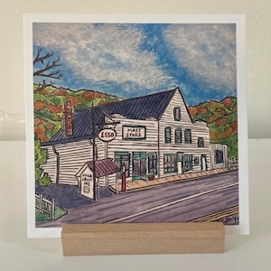 May include: A watercolor painting of a white building with a sign that reads "Mast Store" and "Esso". The building has a red roof and is surrounded by trees. The painting is set against a blue sky with white clouds.