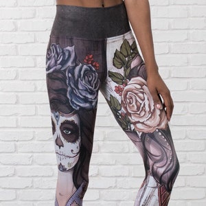 May include: Black leggings with a colorful print featuring a skull with flowers and a woman's face. The print is a Day of the Dead theme.