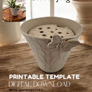Può includere: Modello stampabile per un vaso a rana per fiori con un design a farfalla. Il vaso è bianco e ha una superficie testurizzata. Il modello include istruzioni per la realizzazione del vaso.