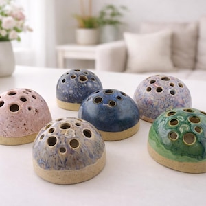 May include: A set of three ceramic mugs with a speckled, matte finish in cream, light grey, and dark grey. Each mug has a minimalist design, ideal for coffee or tea.