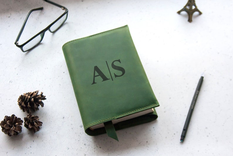 May include: A green leather journal with a bookmark and the initials "A|S" embossed on the front cover.