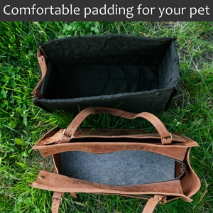 May include: Two pet carriers are shown on grass. The top carrier is black with a quilted interior. The bottom carrier is brown leather with a grey interior. The text "Comfortable padding for your pet" is at the top.
