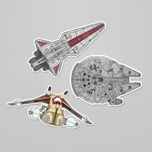 May include: Three sticker designs featuring spacecraft from a science fiction franchise. The stickers include a white and red spacecraft, a circular grey spacecraft, and a tan and red spacecraft with blue accents.