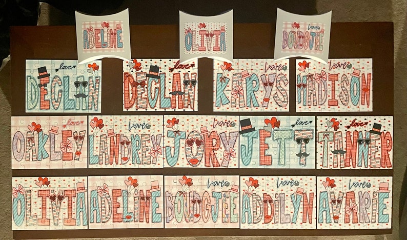 Pode incluir: Um conjunto de 12 pe&ccedil;as de quebra-cabe&ccedil;a personalizadas com nomes como Declan, Olivia e Adeline. Cada pe&ccedil;a apresenta um esquema de cores vermelho, branco e azul com um design de cora&ccedil;&atilde;o e la&ccedil;o. As pe&ccedil;as est&atilde;o dispostas em tr&ecirc;s filas de quatro.