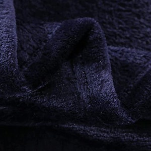 May include: Close-up of a dark blue plush fabric with a soft, fuzzy texture.