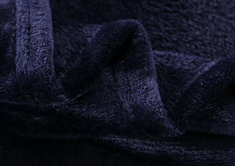 May include: Close-up of a dark blue plush fabric with a soft, fuzzy texture.