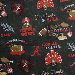 May include: A black fabric featuring a repeating pattern of University of Alabama logos, turkeys wearing football helmets, footballs, pies, and autumn leaves. Text includes "Gobble Gobble," "Give Thanks," "Turkey Bowl," and "Time to get Basted!"