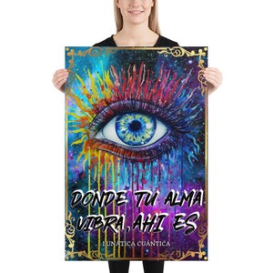 May include: A vibrant poster featuring a detailed eye illustration with a blue iris and colorful accents. The artwork includes text in Spanish: "DONDE TU ALMA VIBRA, AHI ES" and "LUNÁTICA CUÁNTICA" in a decorative gold frame, set against a cosmic background.