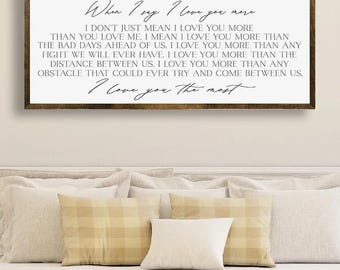May include: A framed wooden sign with the text "When I say I love you more" in a bedroom setting. The sign features a romantic quote in a handwritten style. The bottom of the image has the text "FULLY CUSTOMIZABLE - SIZES, COLORS, FONTS".