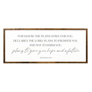 May include: A framed wood sign with a white background and black text. The text reads "For I know the plans I have for you, declares the Lord, plans to prosper you and not to harm you, plans to give you hope and a future. Jeremiah 29:11"
