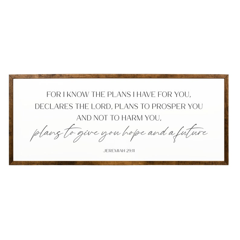 May include: A framed wood sign with a white background and black text. The text reads "For I know the plans I have for you, declares the Lord, plans to prosper you and not to harm you, plans to give you hope and a future. Jeremiah 29:11"