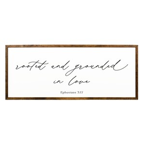 May include: A wooden framed sign with the text "rooted and grounded in love" and the scripture reference "Ephesians 3:17".