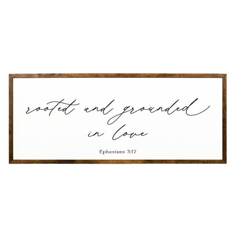 May include: A wooden framed sign with the text "rooted and grounded in love" and the scripture reference "Ephesians 3:17".