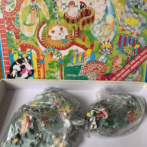 May include: A 150-piece jigsaw puzzle with a vibrant garden scene illustration, including cartoon characters and the word "START". The puzzle pieces are packaged in plastic bags within the box.