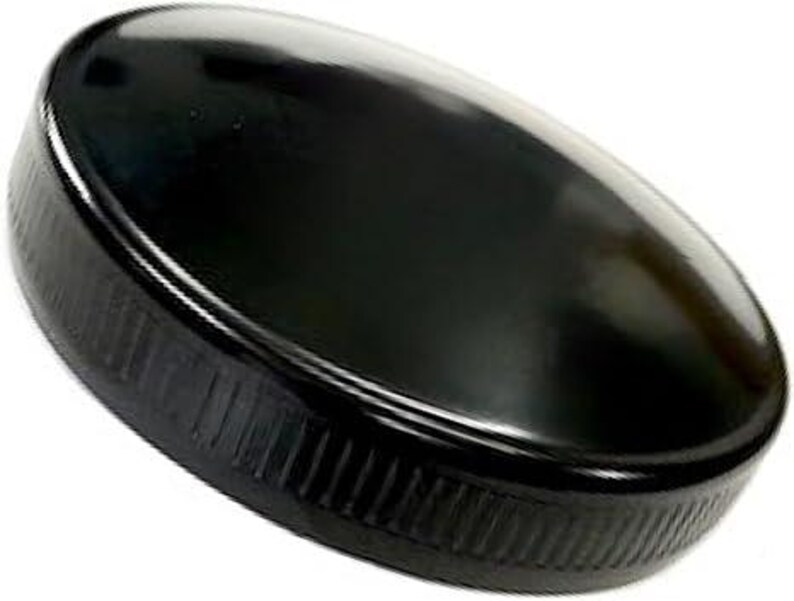 May include: A black plastic bottle cap with a ridged edge.